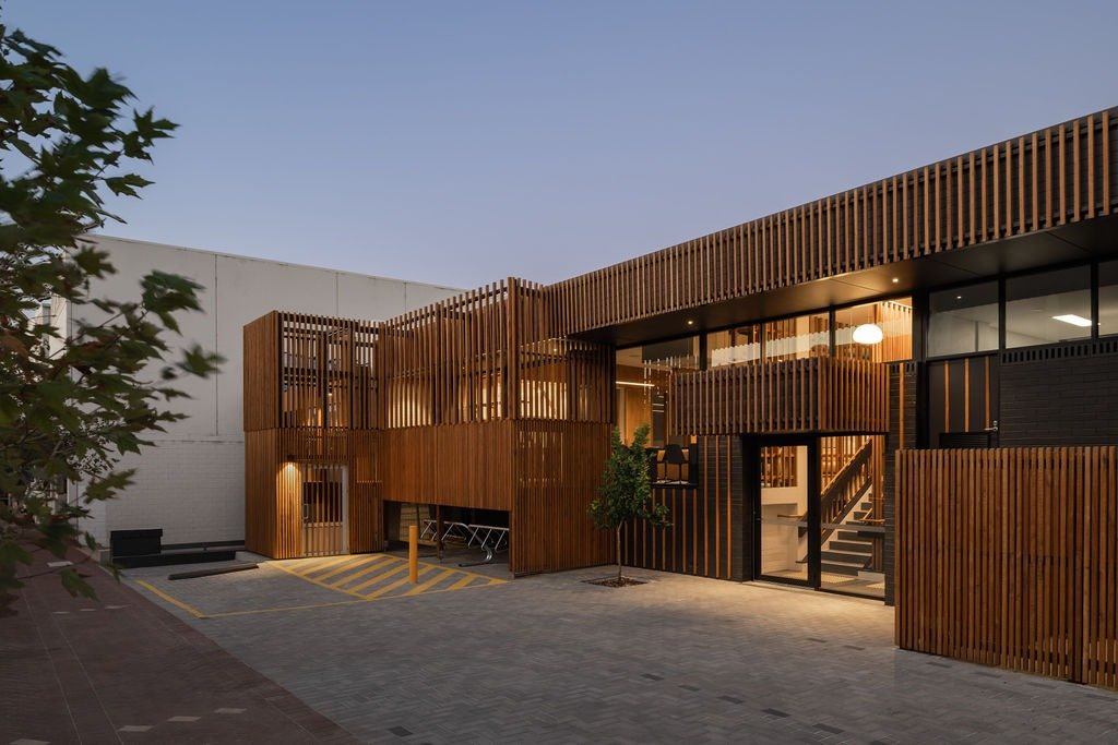 Vitality House at dusk, its timber-battened facade lit from within, on Southport Street West Leederville.