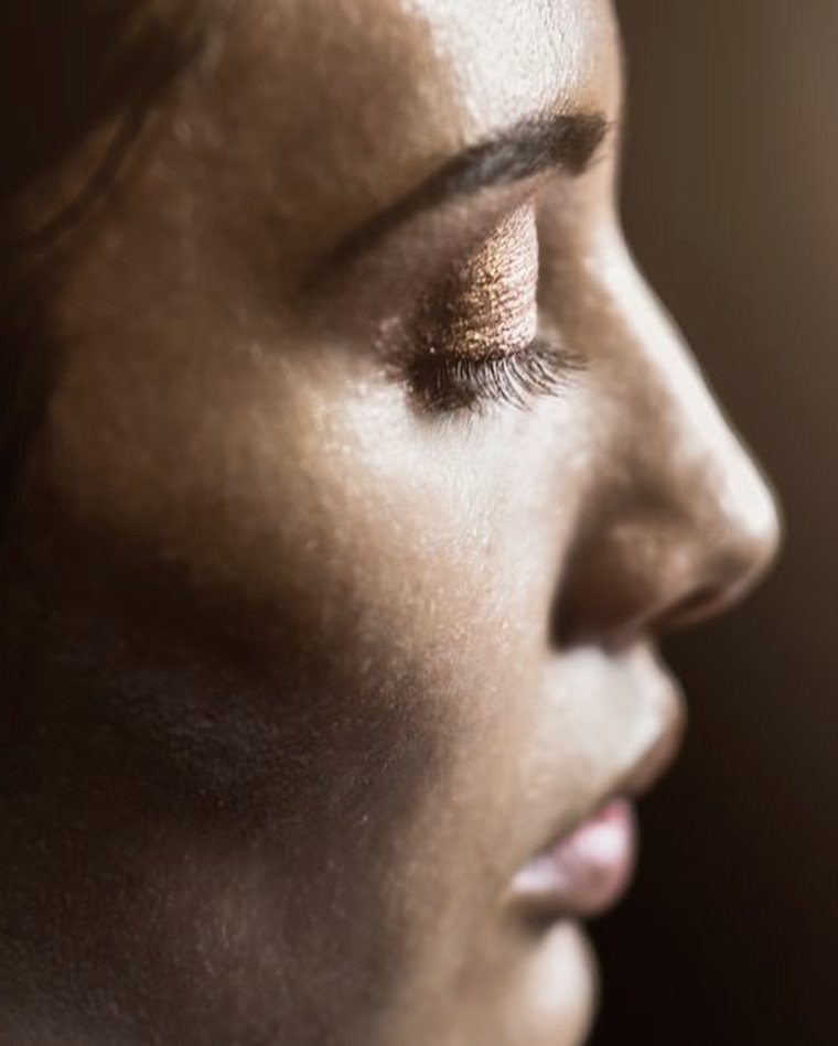 Profile close-up in warm light showing lifted, tinted lashes.